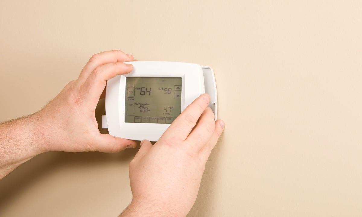 HVAC professional installing a new thermostat in Los Angeles.