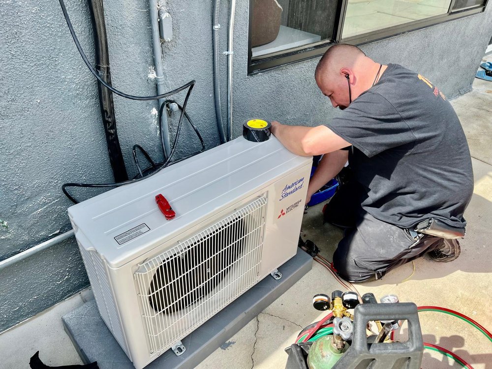 Technician servicing AC unit in Los Angeles home