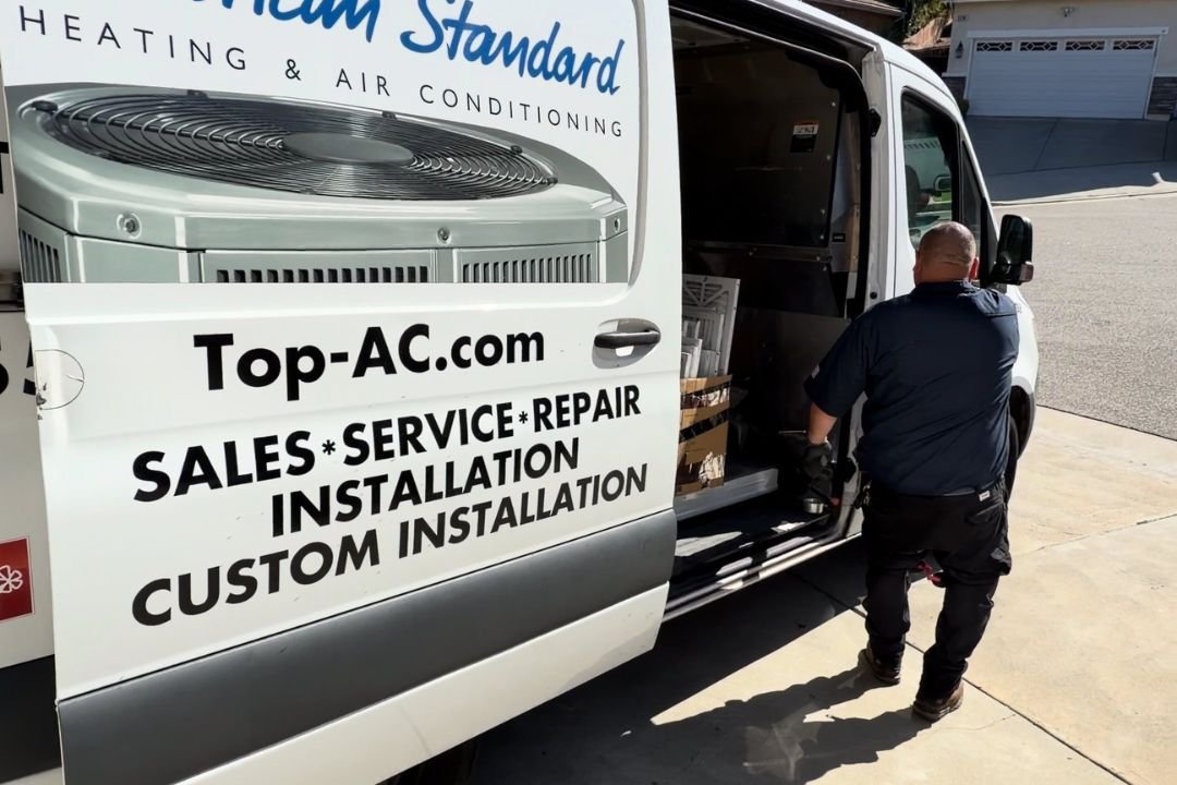 TOP AC technician inspecting home air filtration system